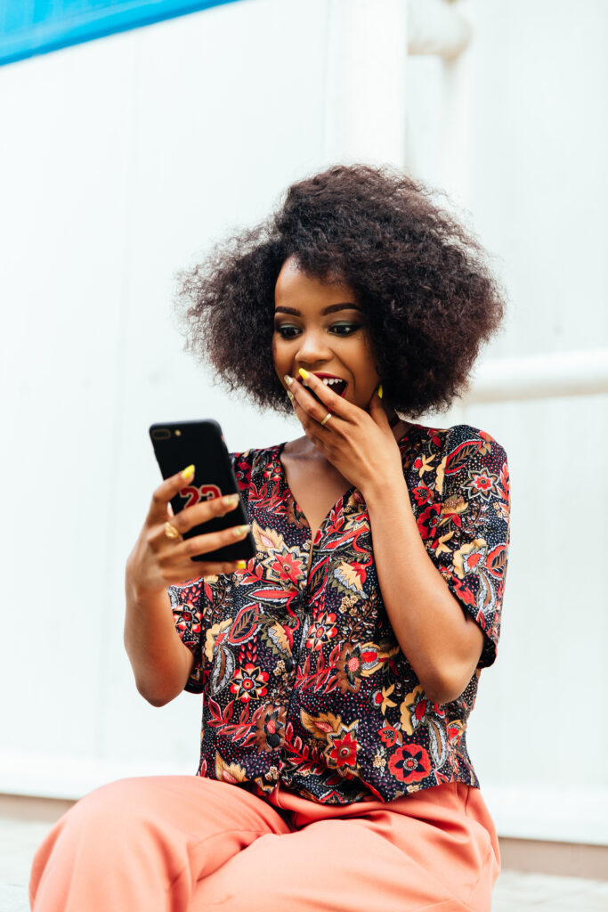 Woman appearing shocked while using a smartphone. PHOTO/Freepik
